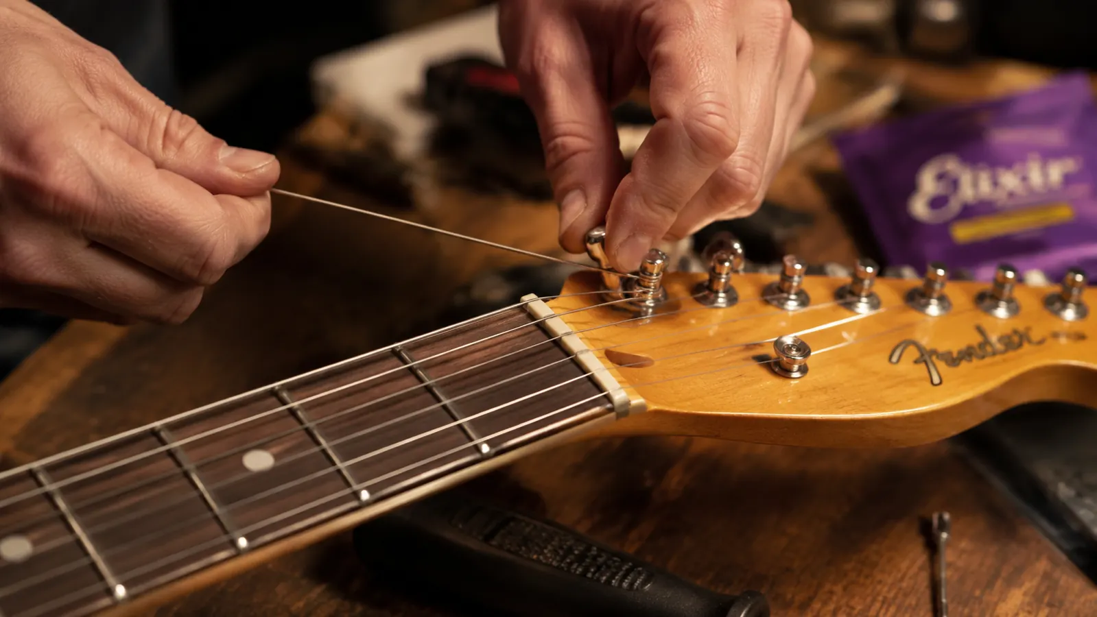 Guitarist playing hard at a small club gig, low stage light, motion blur on the strumming hand