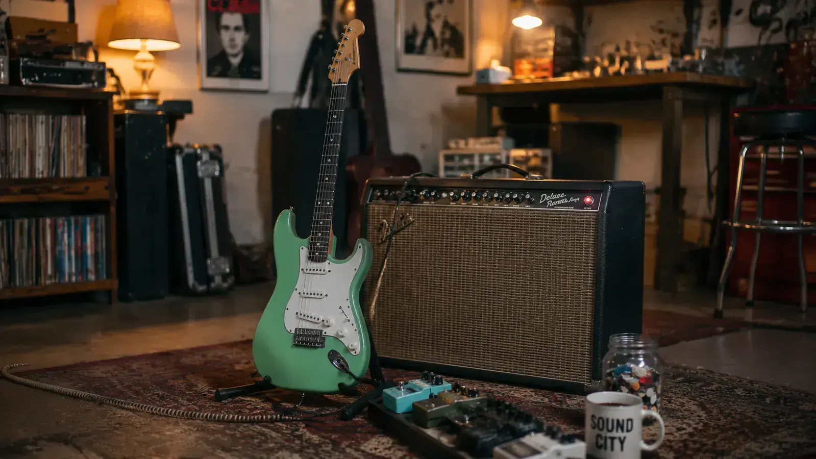 Guitarist playing a Squier Stratocaster at bedroom volume, plugged into a small combo amp