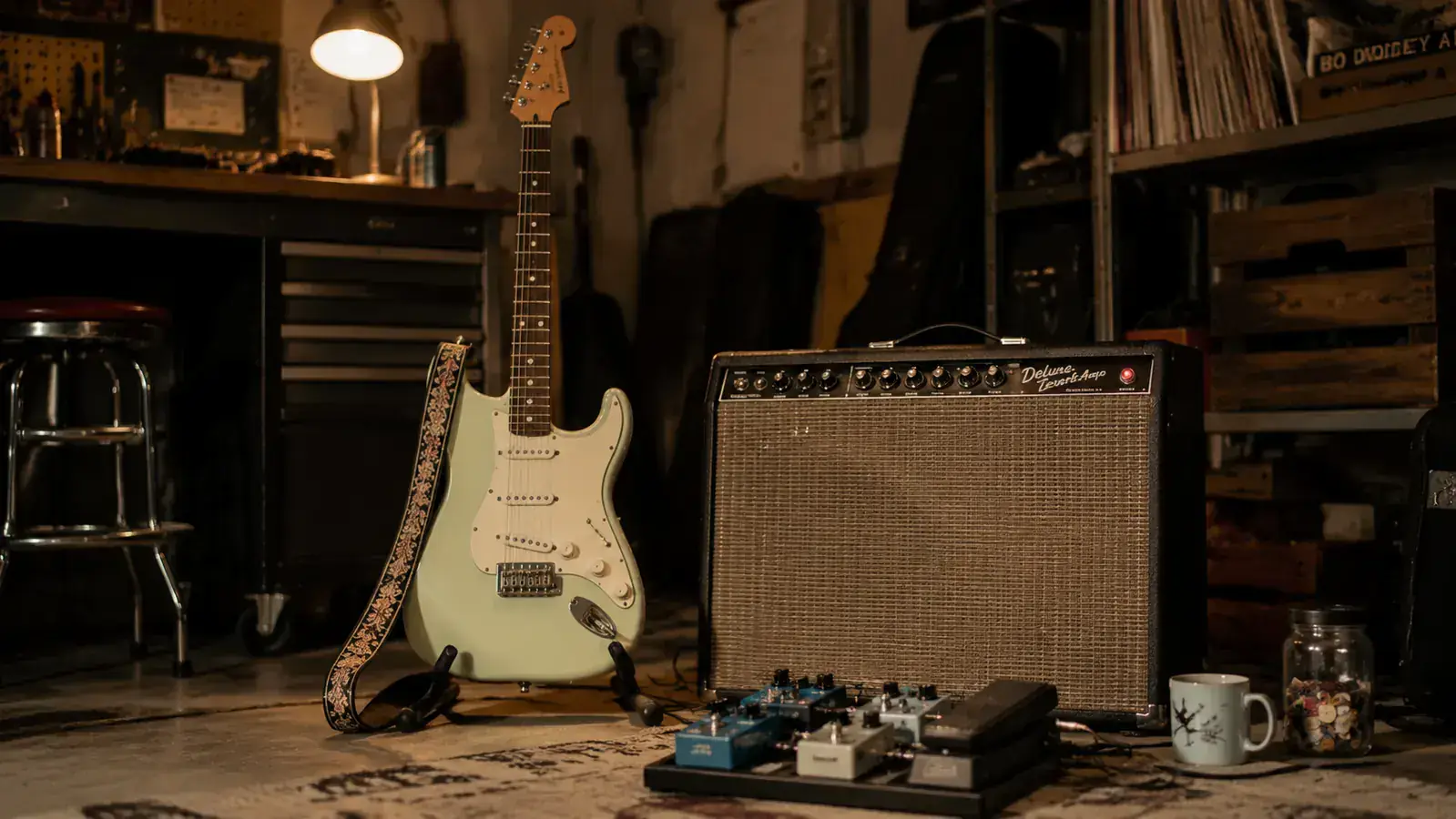 Guitarist playing a Surf Green Stratocaster on a small club stage under red and blue stage lights