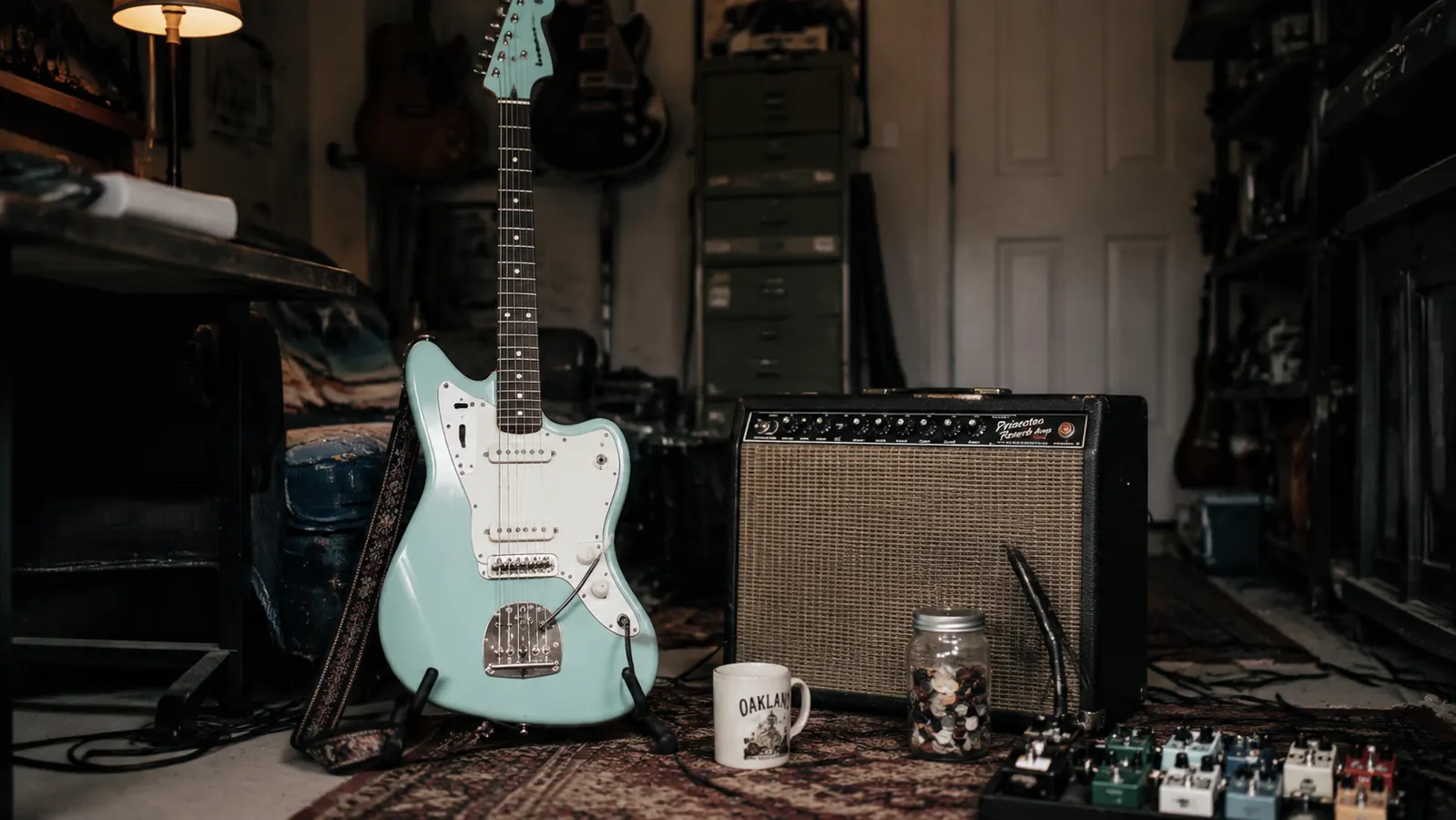 Guitarist playing a Surf Green Stratocaster standing at a small club stage with stage lights behind